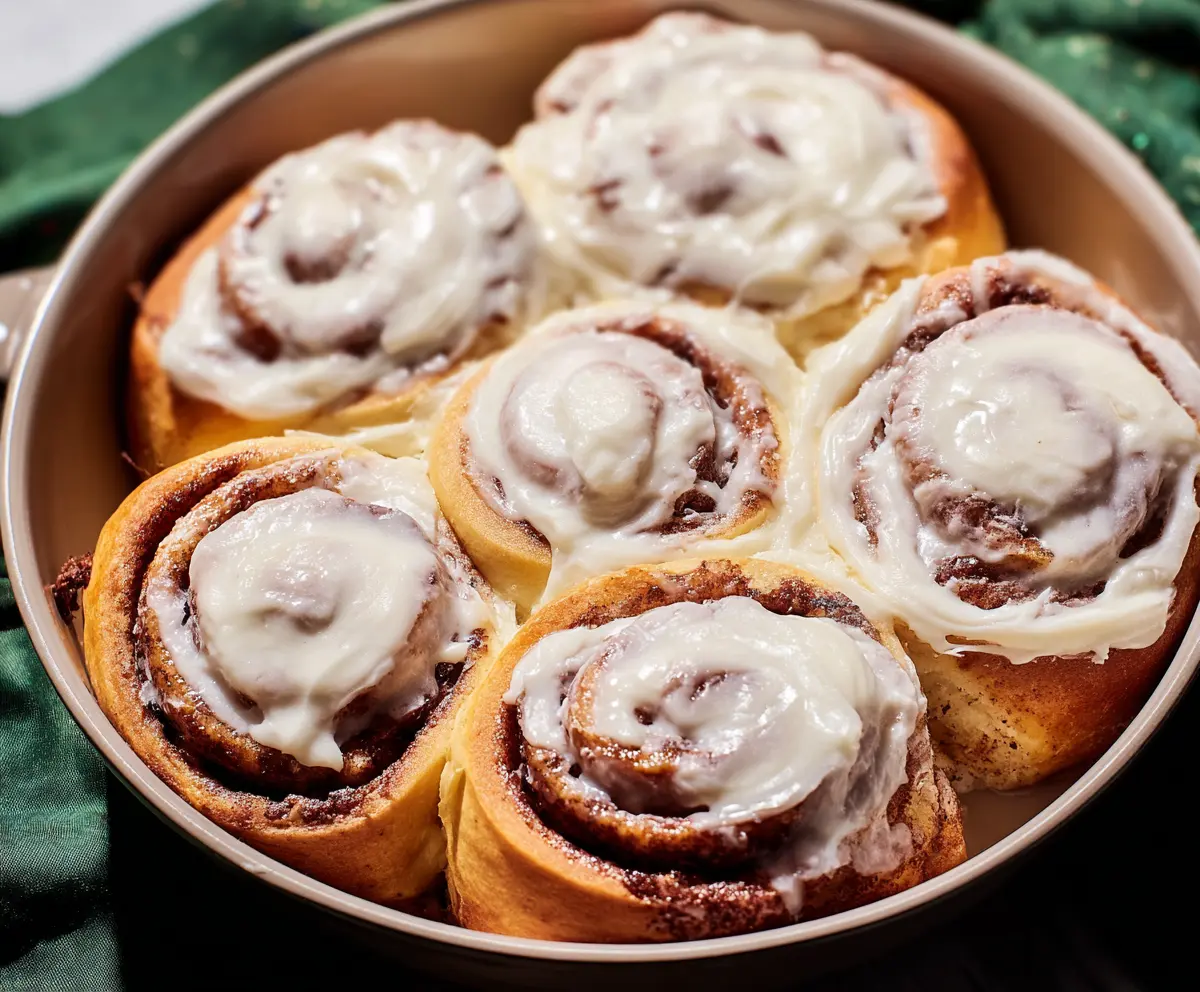 Delicious homemade cinnamon rolls topped with creamy cream cheese frosting, perfect for breakfast or dessert.