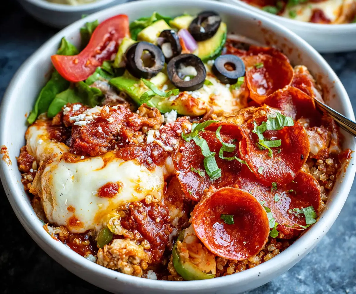 Healthy pizza protein bowl with lean meats, fresh vegetables, and melted cheese in a bowl.