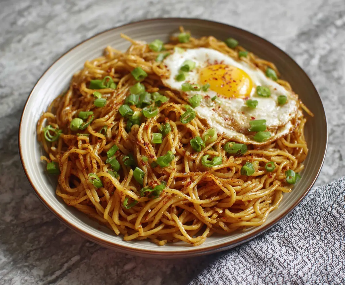 Flavorful Japanese garlic fried noodles garnished with green onions and sesame seeds.