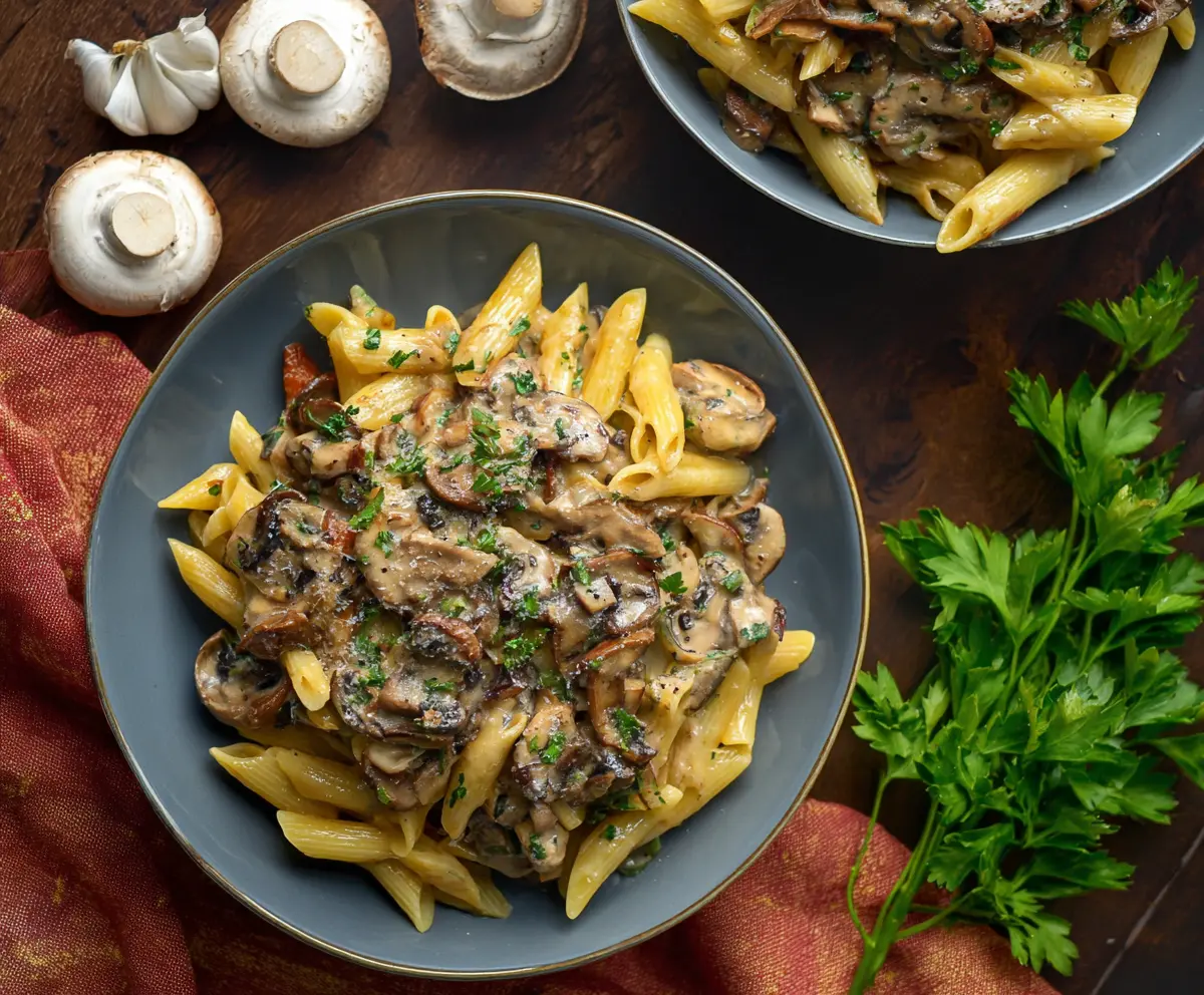 Delicious mushroom pasta with creamy sauce served on a plate, perfect for a hearty vegetarian meal.