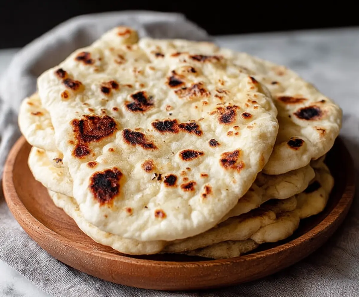 Homemade sourdough discard naan bread fresh out of the oven, showcasing golden-brown, fluffy texture.
