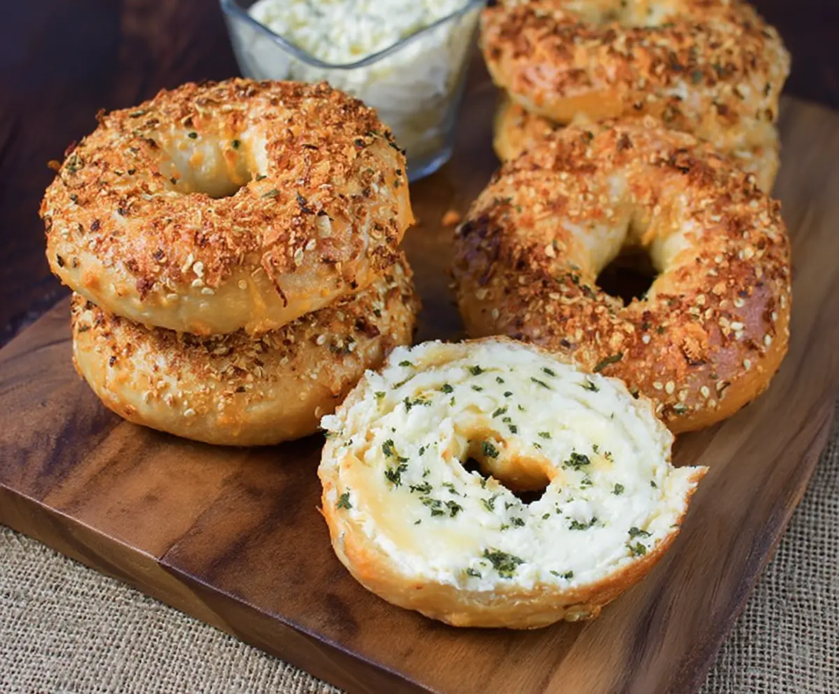 Close-up of golden-brown cream cheese cheddar bagels on a plate, showcasing their creamy filling and crispy crust.