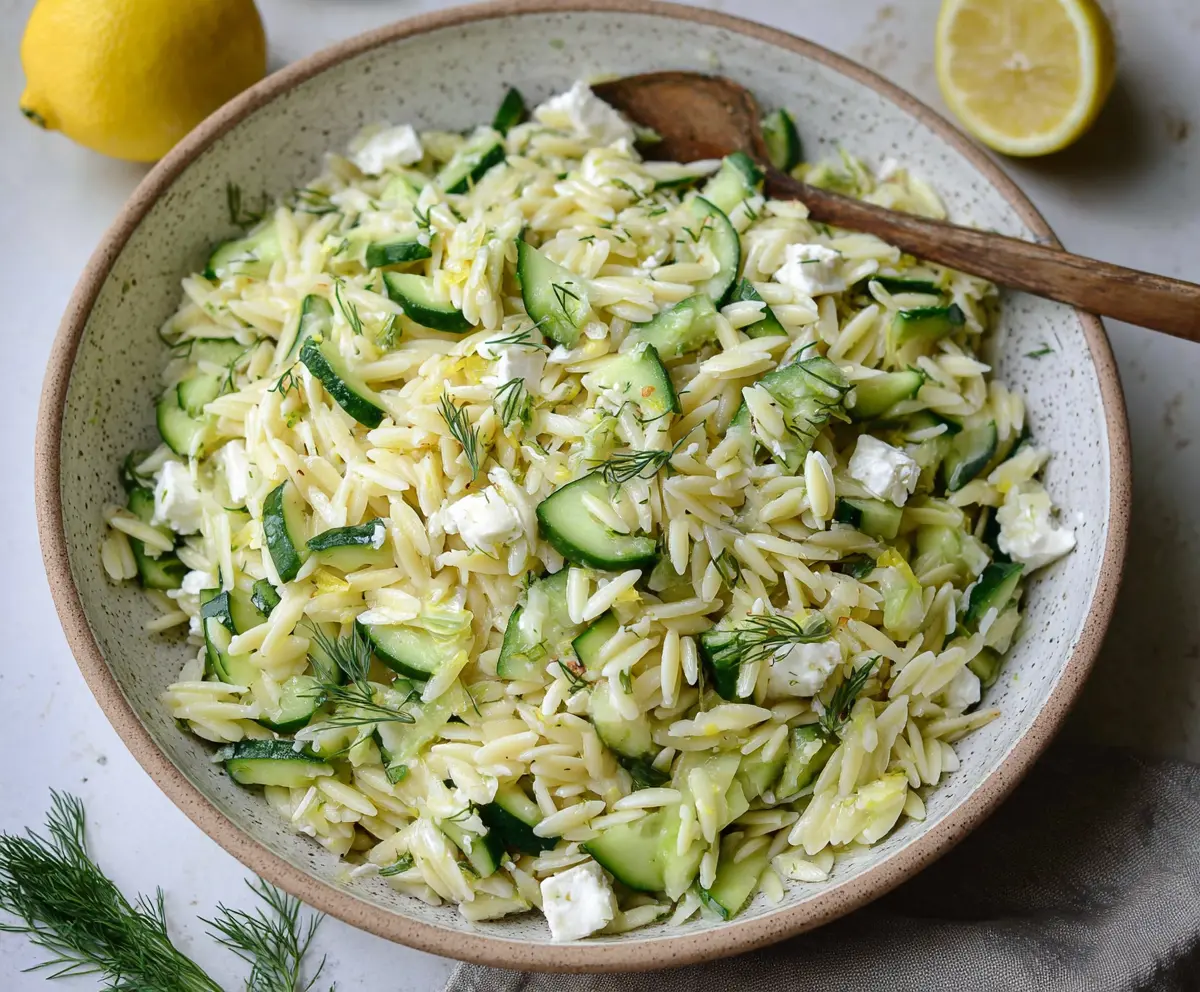 Fresh cucumber and lemon orzo salad in a bowl, perfect for a light, healthy meal.