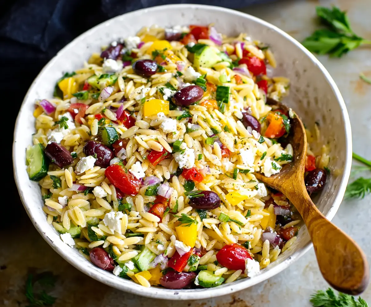 Fresh Greek orzo salad with cucumbers, tomatoes, feta cheese, and olives, perfect for a healthy meal.