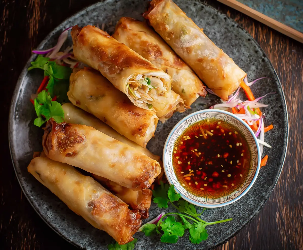 Crispy baked Chinese vegetable spring rolls served on a white plate.