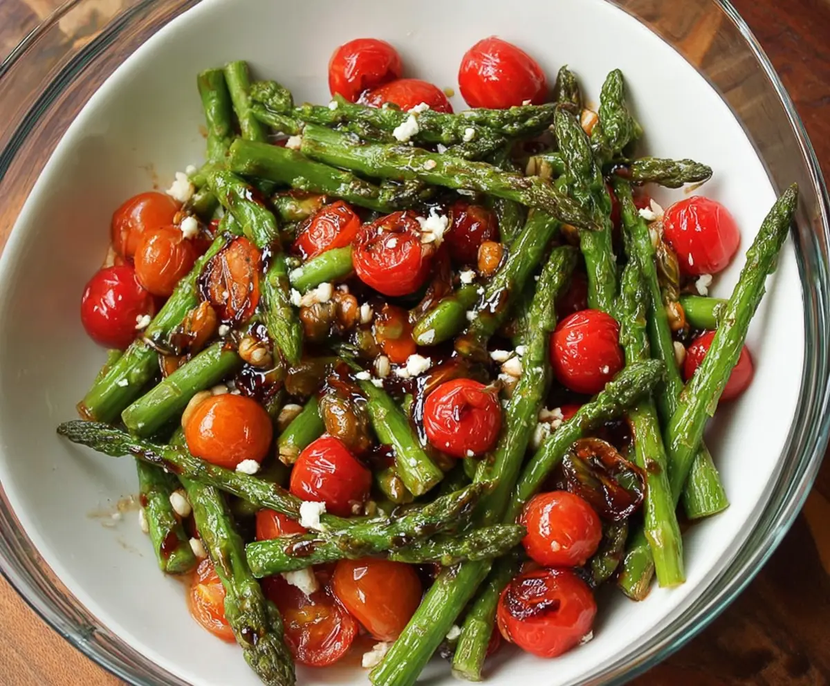 Fresh balsamic asparagus and tomato salad in a bowl, highlighting vibrant vegetables and a tangy dressing.