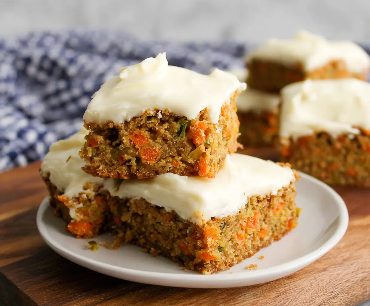 Fresh carrot and zucchini bars topped with citrus-infused cream cheese frosting for a delicious dessert.